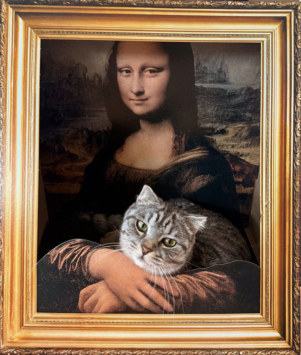 Katze liegt im 3D-Katzenrahmen Mona Lisa – es sieht aus, als halte Mona Lisa die Katze